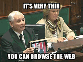 A woman is watching a man speak with hand gestures while a video of a politician speaking plays on a tablet screen. There are files on the table, and text on the screen reads, "It's very thin. You can browse the web."