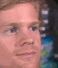 A close-up of a man with blonde hair blinking rapidly in disbelief, showing a confused and slightly shocked expression