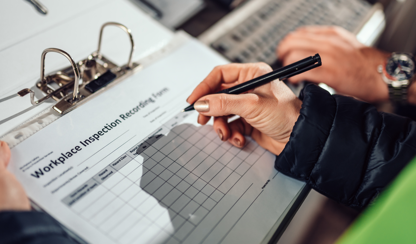 man holding a workplace safety inspection form and filling it in