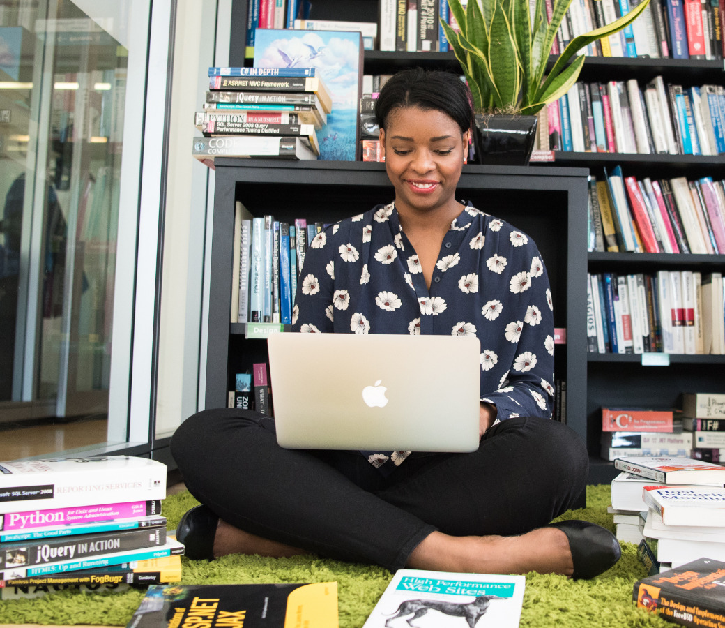 a women sitting on her laptop - employee coaching plan template