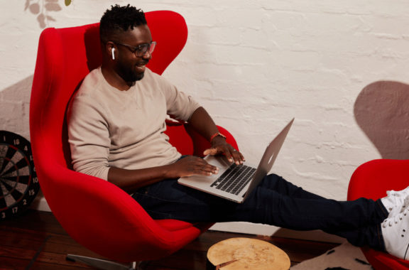 image of a man sitting down on his laptop - distributed workforce