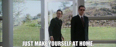 Two men, one man walking in through a door and the other man says 'make yourself at home'