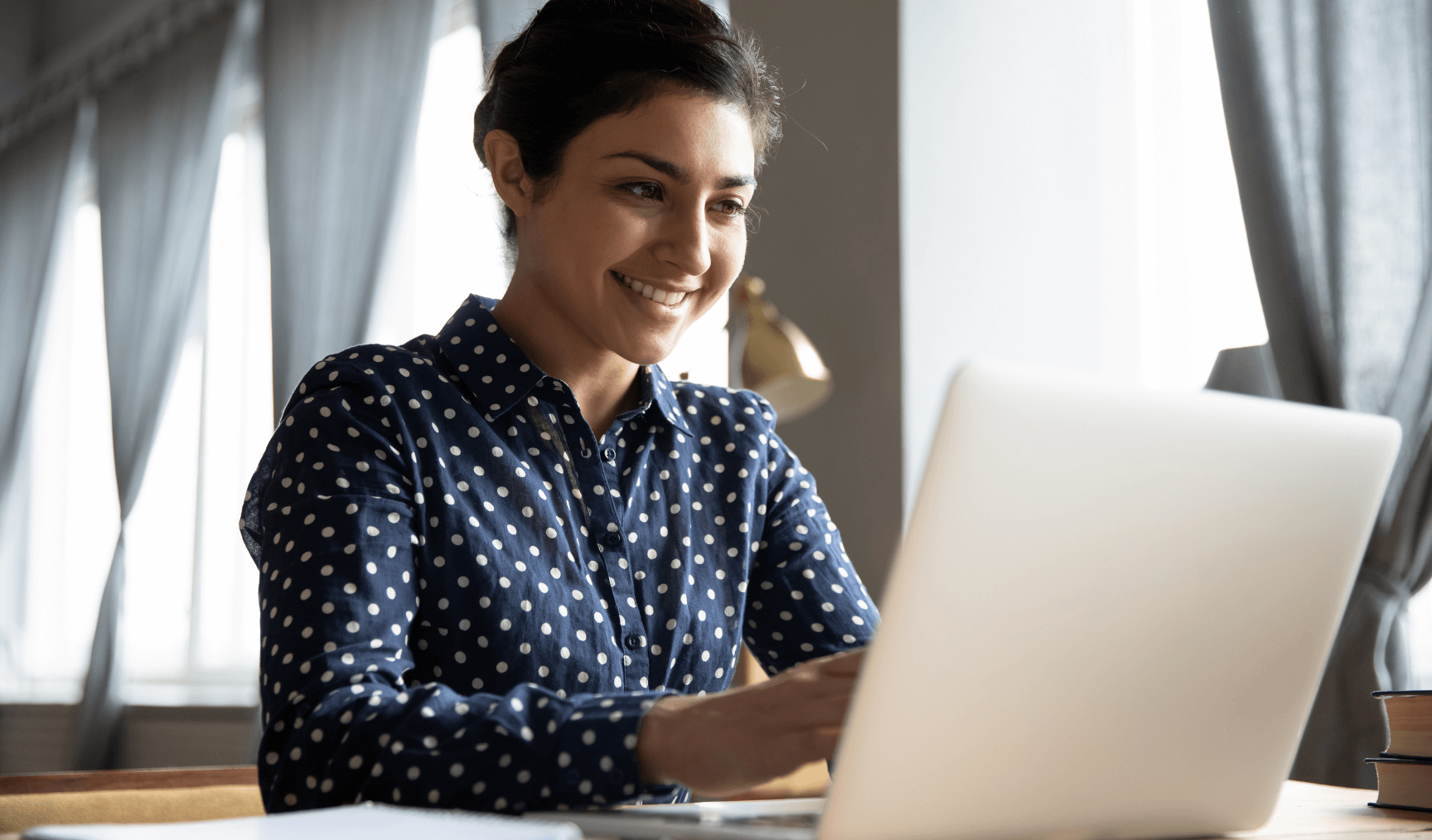 woman smiling and typing on her keyboard