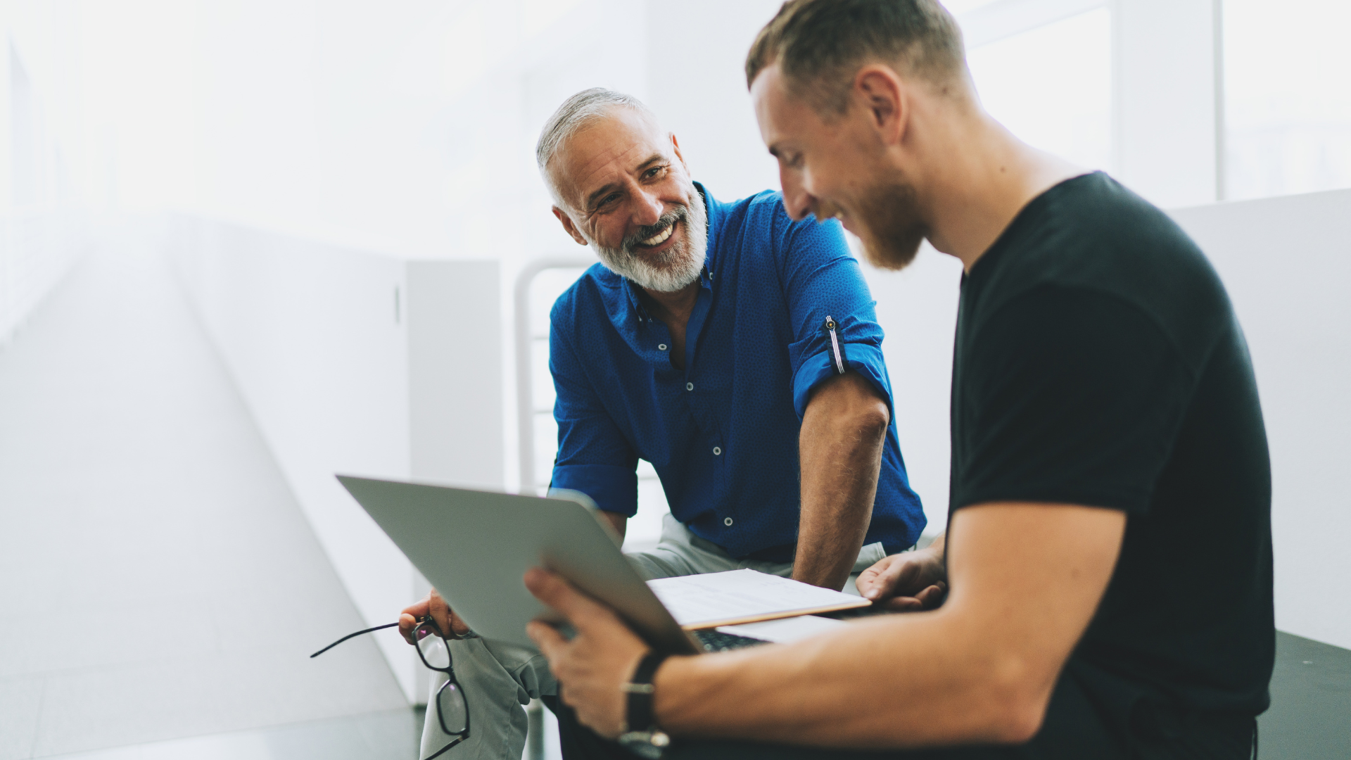 Two men discussing something over a laptoip