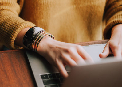 An image of a person typing on a laptop