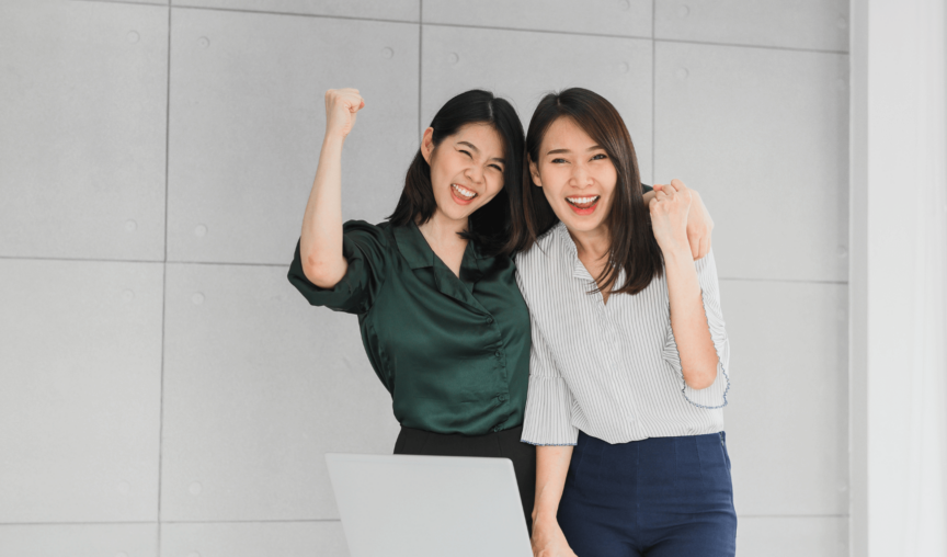 two women smiling at the camera and cheering