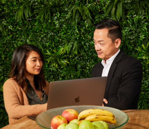 An image of a man and a woman discussing something on a laptop