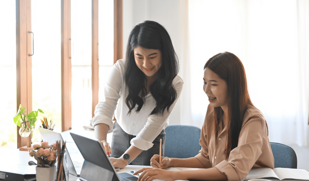 two women working together and smiling