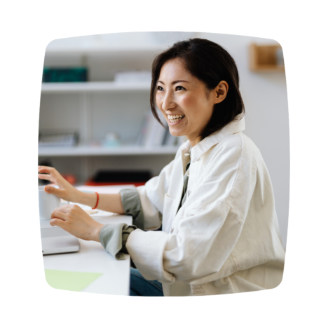 An image of a woman, smiling as she works