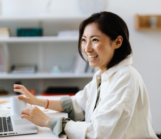 An image of a woman smiling while typing