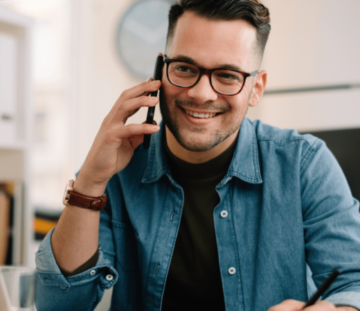 An image of a man smiling on his phone