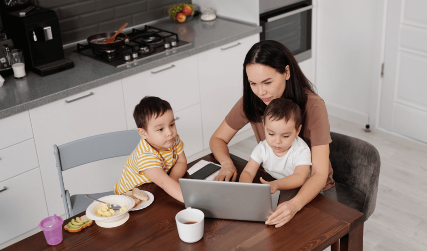 mum trying to work while two kids are at the table with her