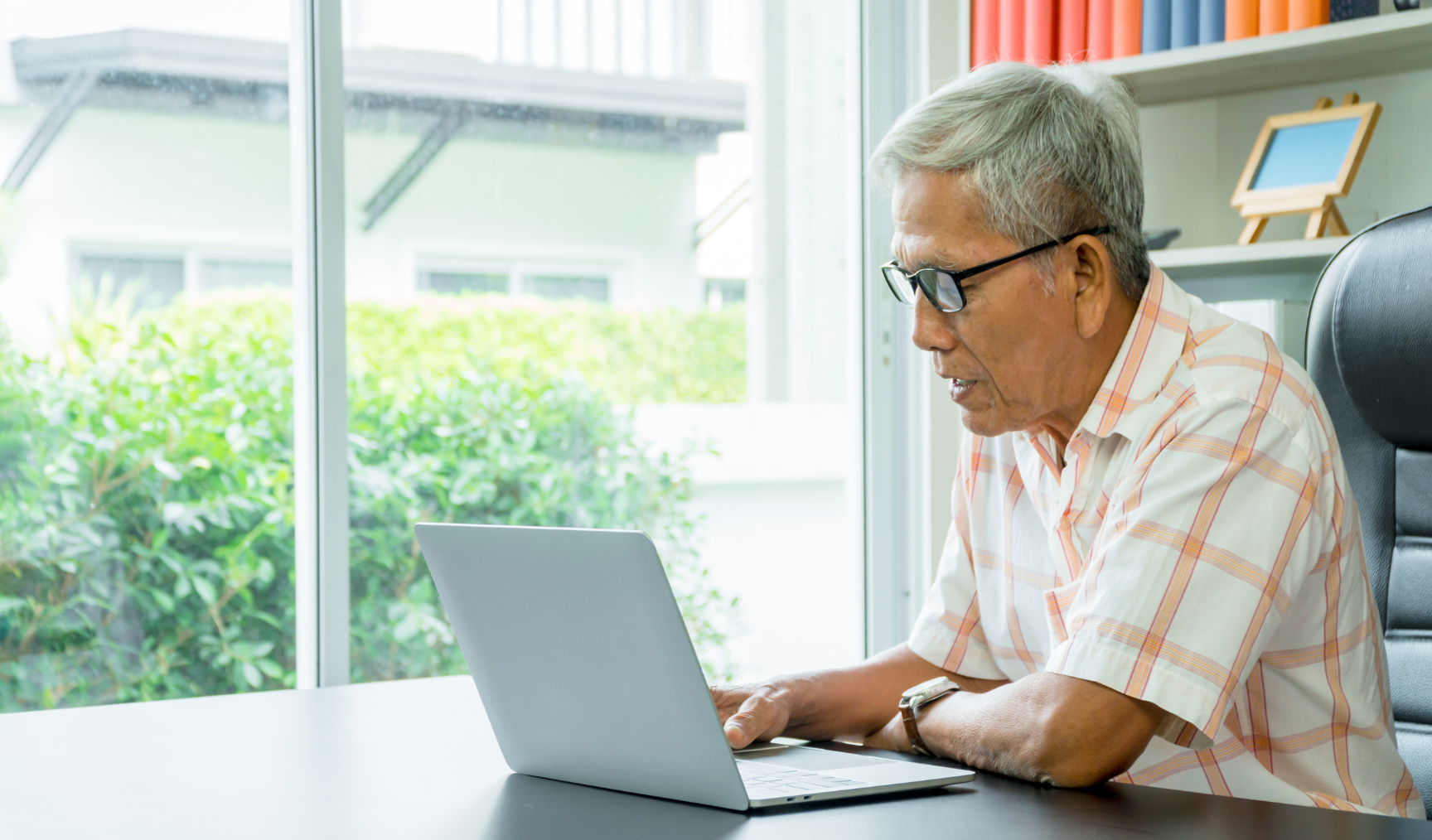 older employee using his laptop at his desk