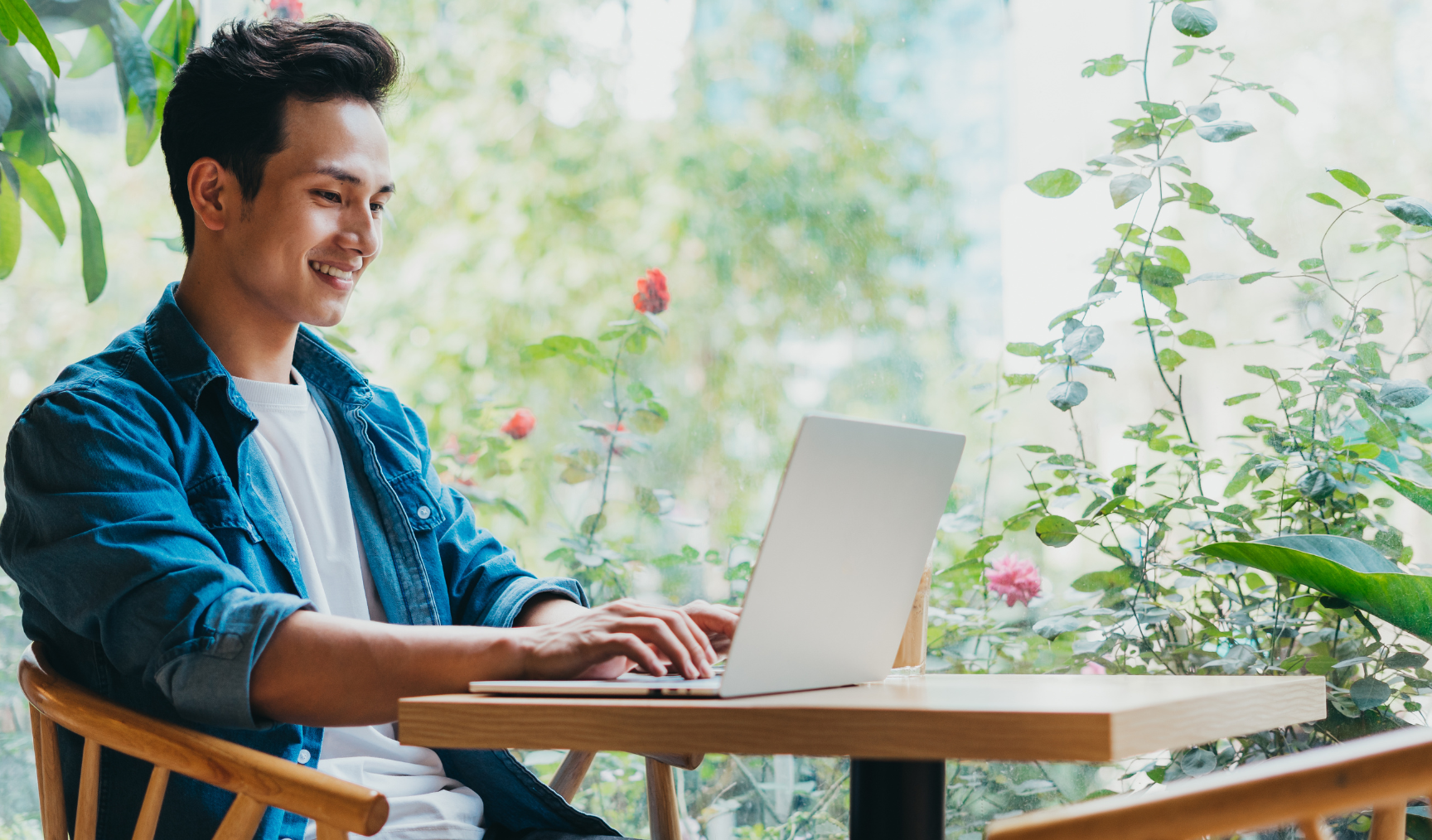 guy smiling while looking at his laptop and typing