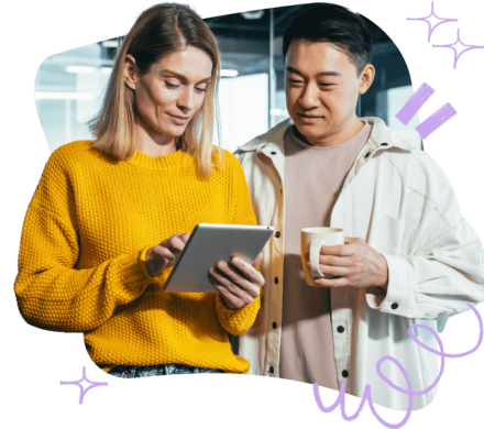 An image of two colleagues discussing something on a tablet, with some sparkles going around