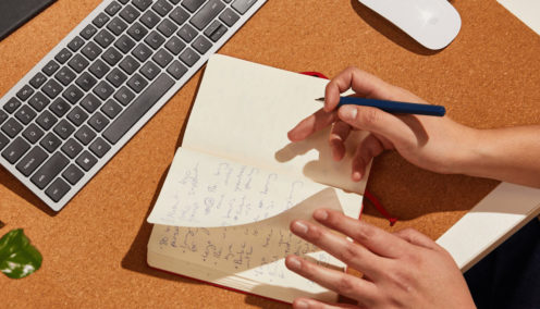Close up of person writing in their notebook