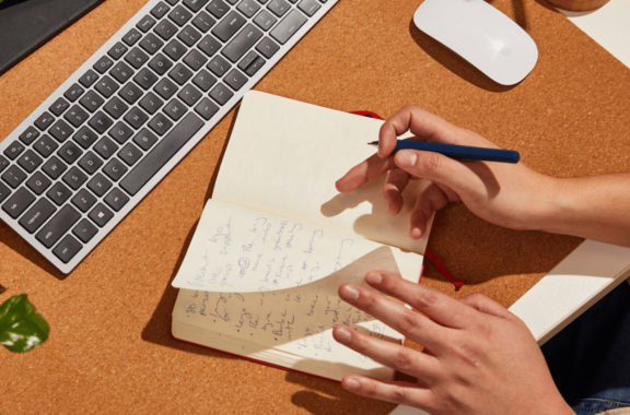 Close up of person writing in their notebook