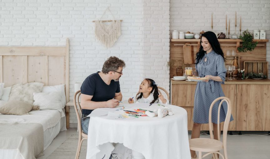 two parents having fun with their adopted kid at home