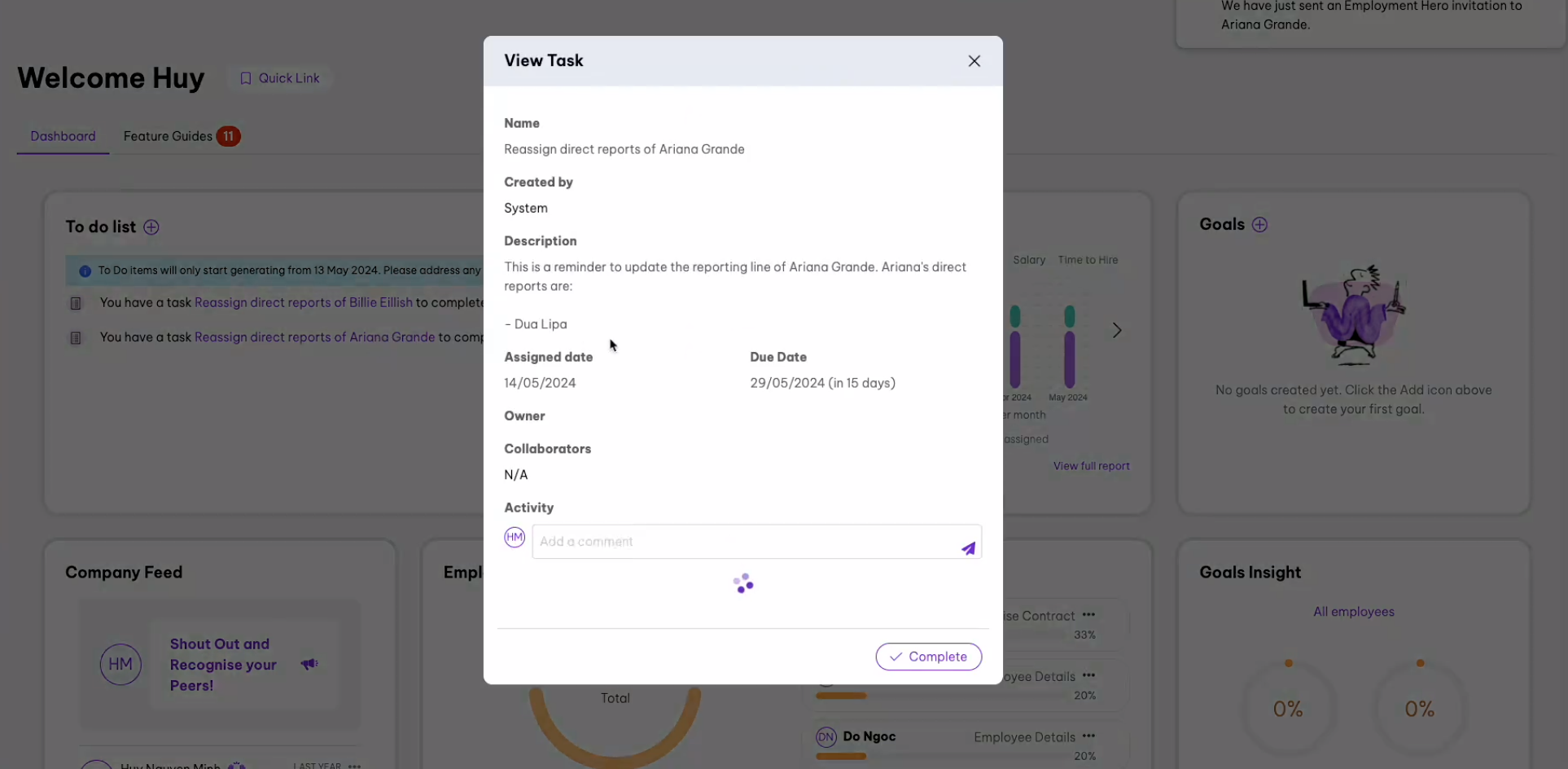 Task view for 'Reassign direct reports of Ariana Grande,' created by the system, with a reminder to update Ariana Grande's reporting line, listing Dua Lipa as a direct report. Details include the assigned date (14/05/2024), due date (29/05/2024), owner, collaborators, and an activity section for comments. The background shows a dashboard with to-do list items and goal widgets