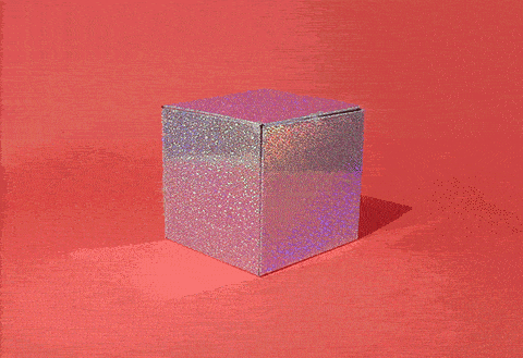 A sparkling silver gift box on a red background pops open to reveal a cat inside