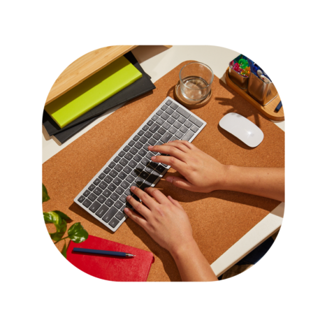 Hands typing on a keyboard at a neat, organized desk