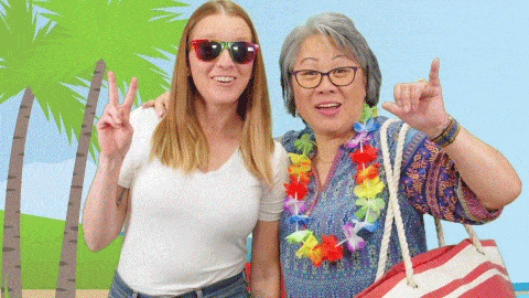 A gif of two women posing in front of a tropical backdrop. One is wearing sunglasses and making a peace sign, while the other has a lei around her neck. There's a text overlay that says, "Vacation Time"