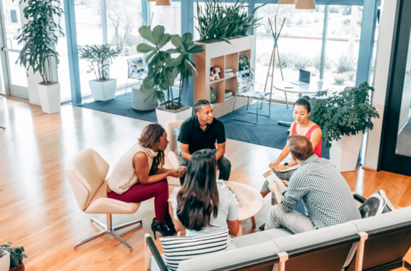 colleagues gathered in a circle chatting in the office