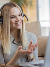 woman smiling while speaking to her laptop on a call