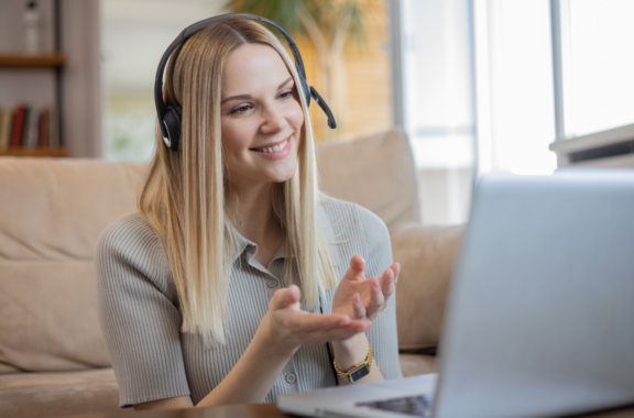 woman smiling while speaking to her laptop on a call